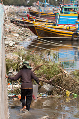 Image showing Woman collecting garbage in a harbour in Vietnam