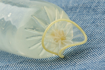 Image showing Condom filled with water on jeans 