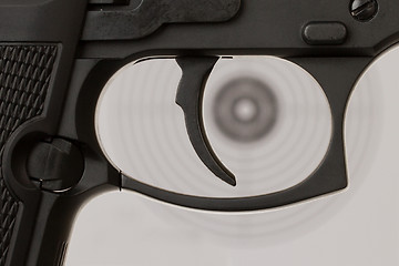 Image showing The trigger of a handgun with a shooting target 