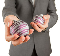 Image showing Man in grey suit is holding Christmass balls
