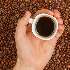 Image showing Cup of coffee on beans. top view