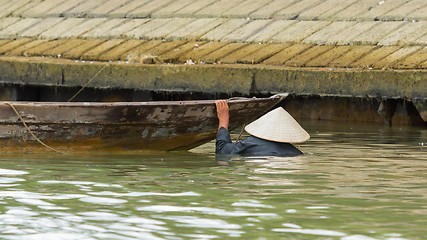 Image showing A vietnamese fisherman is searching for shells in the water