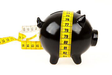 Image showing Black piggy bank with measuring tape