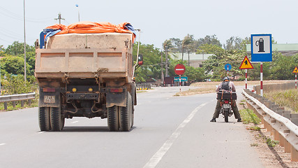 Image showing Big truck passing a motorcycle on a highway