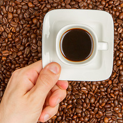 Image showing Cup of coffee on beans. top view