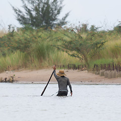 Image showing A vietnamese fisherman is searching for snakes and shells in the