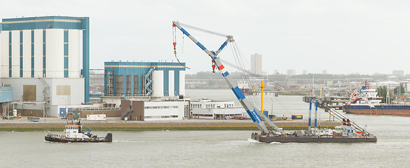 Image showing Tug-boat dragging a crane