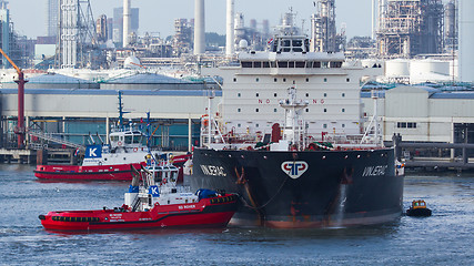 Image showing Two tugboats manoeuvring an oil tanker in the dutch harbor of Ro