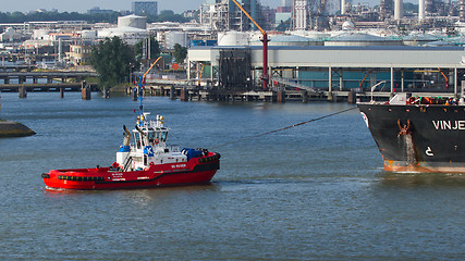 Image showing Two tugboats manoeuvring an oil tanker in the dutch harbor of Ro