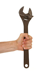 Image showing Old rusted adjustable vector wrench in a hand