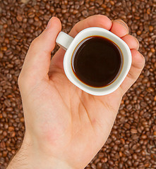 Image showing Cup of coffee on beans. top view