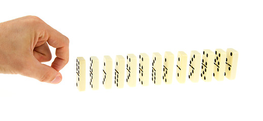 Image showing Hand ready to push dominoes