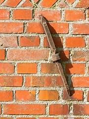 Image showing Old rusty clamp in a brick wall