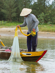 Image showing Fisherman is fishing with a large net in a river in Vietnam