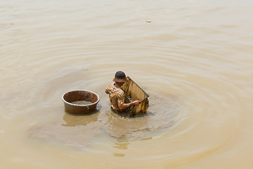 Image showing A vietnamese fisherman is searching for shells in the water