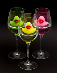 Image showing Green, yellow and pink rubber ducks in wineglasses