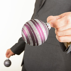 Image showing Man in grey suit is holding Christmass balls