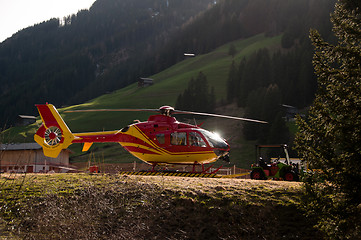 Image showing Grounded Yellow and Red Helicopter At Hangar