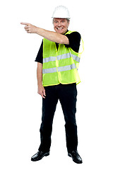 Image showing Cheerful estate engineer indicating sideways