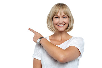 Image showing Smiling woman pointing backwards