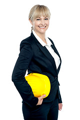 Image showing Pretty business architect with yellow safety helmet in hand