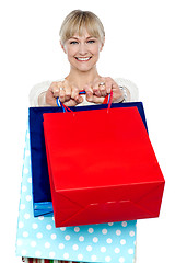 Image showing Woman holding shopping bags in her outstretched arms