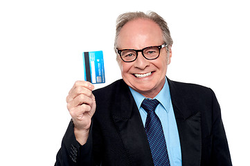 Image showing Old man wearing eyeglasses holding up a cash card