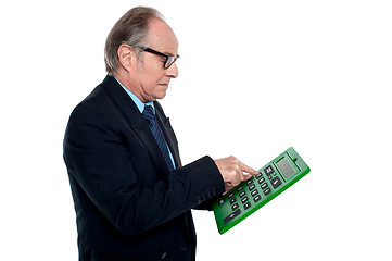 Image showing Intent looking executive working on a calculator