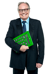 Image showing Senior male manager holding big green calculator