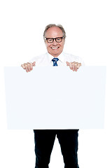 Image showing Senior marketing manager holding up a blank ad board