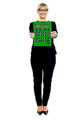 Image showing Woman in business suit displaying large green calculator
