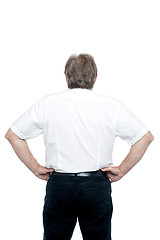 Image showing Back pose of a senior man standing with hands on his waist