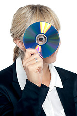 Image showing Corporate lady looking through compact disc hole