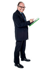 Image showing Cheerful senior businessman using a calculator
