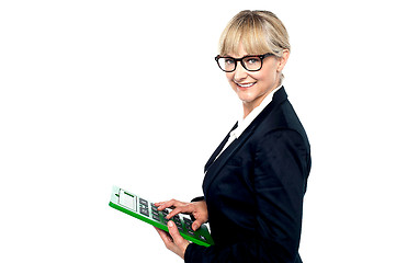 Image showing Bespectacled entrepreneur using a calculator