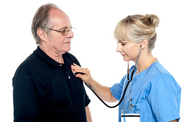 Image showing Female doctor examining an elderly man