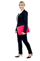 Image showing Energetic employee walking with her clipboard