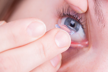 Image showing Close up of inserting a contact lens