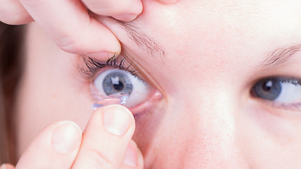 Image showing Close up of inserting a contact lens