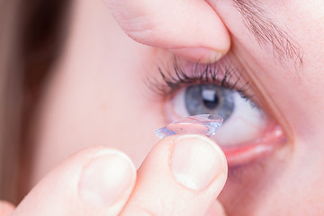 Image showing Close up of inserting a contact lens