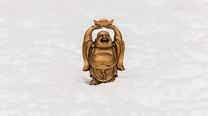 Image showing Small happy Buddha standing in the snow