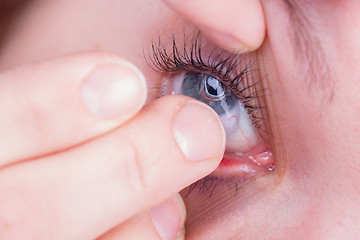 Image showing Close up of inserting a contact lens