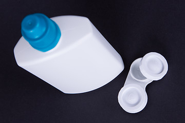 Image showing Lens casing and bottle of water isolated on black