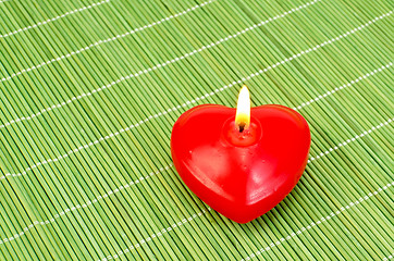 Image showing Heart of red candles on bamboo