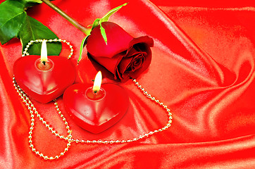 Image showing Heart of a candle with a rose on a red silk