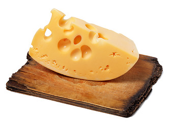 Image showing Piece of cheese on old wooden kitchen board