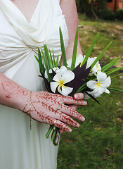 Image showing Bride's hand with henna design and fragapani bouquet