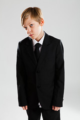 Image showing Serious young boy wearing black suit