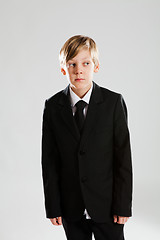 Image showing Serious young boy wearing black suit