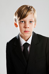 Image showing Serious young boy wearing black suit